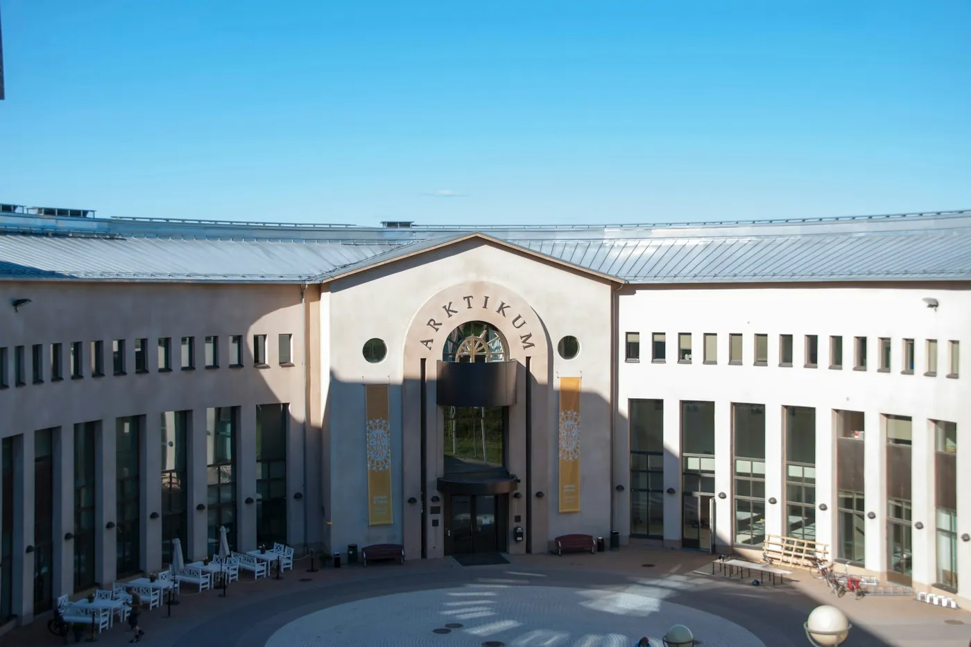 Courtyard and entrance of the Arktikum with its name on the wall, in sunshine